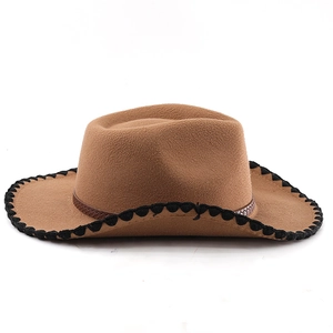 Détail d'un chapeau de cow-boy en laine marron avec bords noirs et bande en cuir tressé