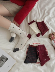 Detail of red festive cotton socks with heart patterns and vintage bow ties