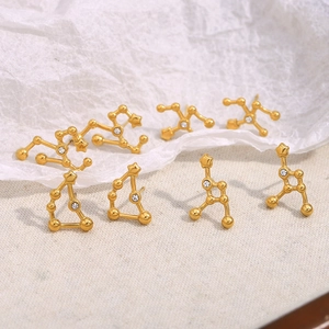 Detailed shot of 18K gold plated stainless steel zodiac stud earrings with small crystals