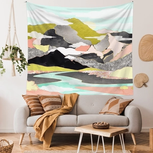 Abstract mountain landscape tapestry hanging above a modern sofa for home wall decor