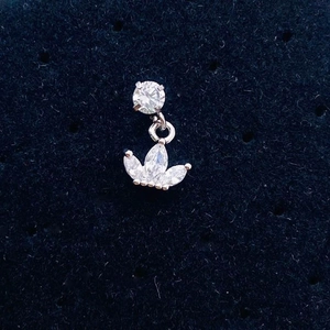 Macro detail of silver stainless steel zircon ear stud with crown leaf design on black felt