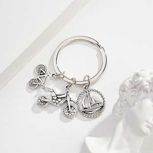 Silver metal keychain featuring detailed bicycle, motorcycle, and sailboat charms