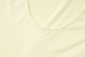 Close-up of seamless round neckline and fine knit texture on light yellow slim jumpsuit