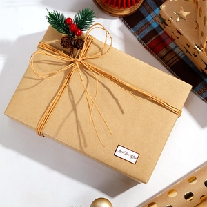 Brown kraft gift box with pine cones and berries wrap in holiday packaging