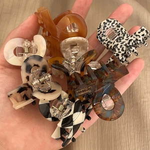 Close-up of acetate hair claw clips in tortoiseshell, cow print, and checkered patterns