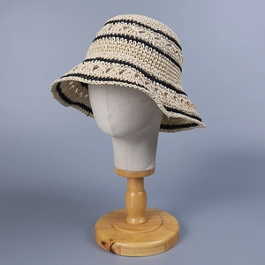 Detail of hand-woven straw bucket hat with black stripes and hollow crochet pattern