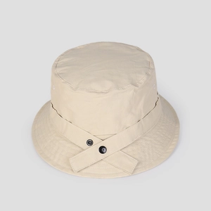 Detail of beige quick-dry nylon bucket hat featuring crisscross straps and black buttons