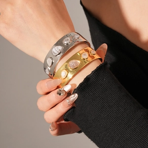 Détail de bracelets ouverts plaqués or et argent avec incrustations de pierres fines