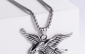 Detail of vintage eagle pendant necklace with wings spread on white platform