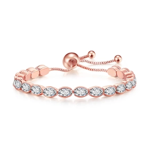 Macro detail of rose gold tennis bracelet with oval cut white zircons and pull chain