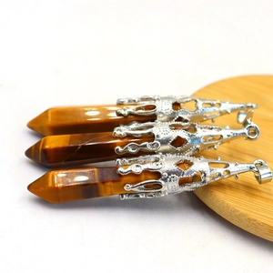 Detailed close-up of tiger eye stone bullet pendants with ornate silver metal caps