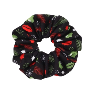 Close-up of black festive scrunchie with Christmas patterns like holly and snowflakes