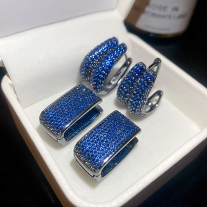 Macro detail of blue zircon teardrop earrings set with black plating and pave setting