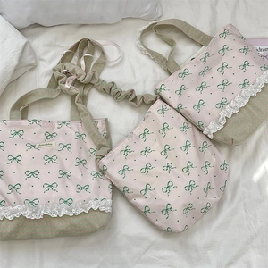 Detail of sweet pink lace tote bag with green bow print and checkered fabric stitching