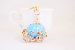 Detailed close-up of light blue enamel pumpkin carriage keychain with white rhinestones