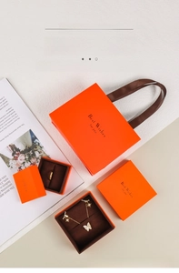 Elegant orange jewelry packaging set with gift bag and boxes for rings and necklaces