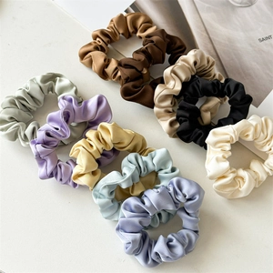 Gros plan de chouchous en satin de couleurs Morandi avec une texture lisse
