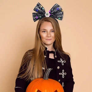 Girl wearing Halloween LED headband with black spider web bow and realistic eyeball detail
