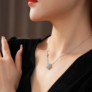 Gros plan détaillé d'un collier trèfle orné de zircons porté sur le cou d'une femme