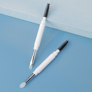Dual-ended eyebrow brush with black spiral spoolie and white silicone applicator head