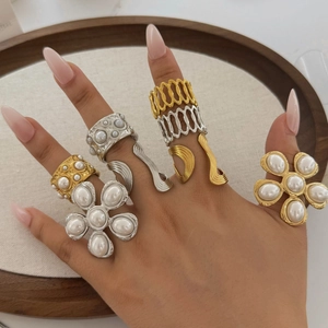 Floral pearl stainless steel rings in gold and silver finish on a female model hand
