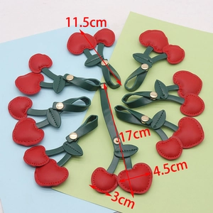 Vista de detalle de llaveros de cereza en cuero con medidas 11,5 cm y 17 cm