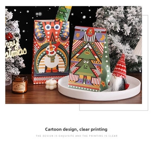 Close-up of colorful Christmas kraft paper gift bags with cartoon snowman and tree patterns