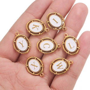 Oval gold plated stainless steel charms with white enamel and A-Z capital letters
