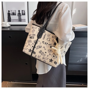 Close-up of graffiti print tote bag featuring a cute white plush bunny charm
