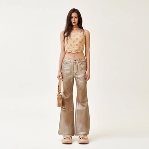 Chic women's gold metallic flared jeans paired with a cross-embroidered tube top