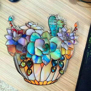 Detail of colorful stained glass acrylic succulent hanging ornament on a wooden background