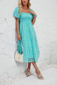 Detail of light blue tiered maxi dress with smocked bodice and puff sleeves on a model