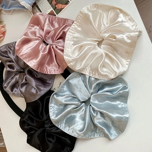 Detailed view of large satin scrunchies in five colors including pink, white and blue