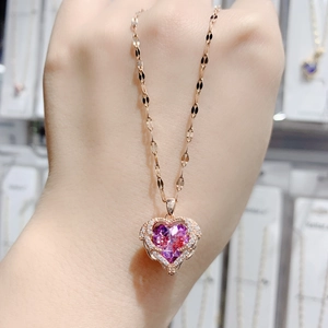 Makroaufnahme von Herzanhänger aus Roségold mit lila Kristall und kleinen Diamanten
