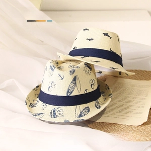 Detail of cream woven straw hats for kids with navy ribbons and summer surf patterns