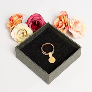 Two-tone rose gold ring in a jewelry box with craft paper price tag and roses