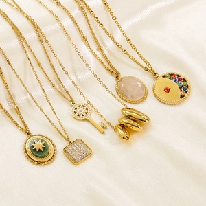 Polished gold stainless steel necklaces with natural stones on beige silk fabric