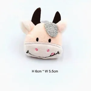 Détail d'un accessoire en peluche vache de 6cm x 5.5cm avec des broderies délicates