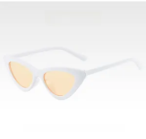 Detail view of cat-eye sunglasses with white plastic frames and champagne-colored lenses