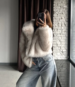 Detail of off-white faux fox fur short jacket showing thick soft texture and lapel collar