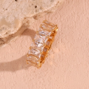 Macro shot of 18K gold plated ring with square cubic zirconia on a pink textured surface
