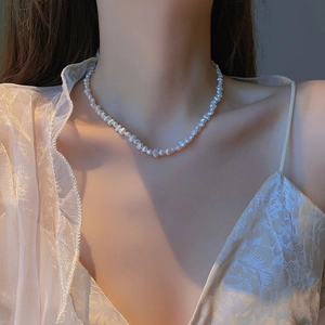 Elegant baroque freshwater pearl necklace worn by a model in soft natural indoor lighting