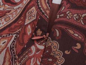 Macro di una cerniera invisibile e motivo paisley su tessuto per abiti bordeaux