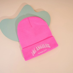 Détail d'un bonnet en tricot rose vif avec broderie blanche Los Angeles Vintage