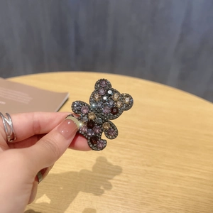 Detailed macro view of a sparkling rhinestone bear hair clip with colorful crystal accents