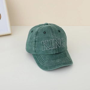 Dettaglio del cappello vintage verde con ricamo KING bianco e finitura in cotone lavato