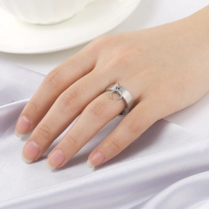 Fashion silver minimalist ring with moon pendant charm on a soft silk fabric background
