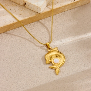 Minimalist gold dolphin necklace with iridescent white opal on sand stone background