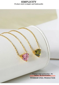 Detail view of heart-shaped pink and green zircon pendants on titanium steel chains