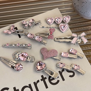 Detailed close-up of pink heart rhinestone hair clips and butterfly metal hairpins